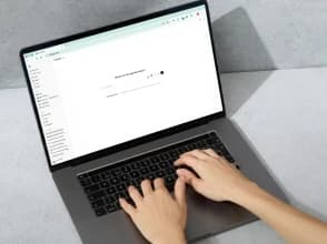 Person typing on a laptop using the ChatGPT interface on screen.