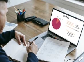 Professional reviewing a digital advertising budget and media plan on a laptop.