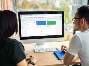 Two professionals reviewing Google Tag Manager setup on a desktop computer.