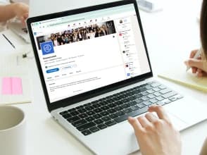 Person managing a Knowcrunch LinkedIn company page on a laptop at a desk.